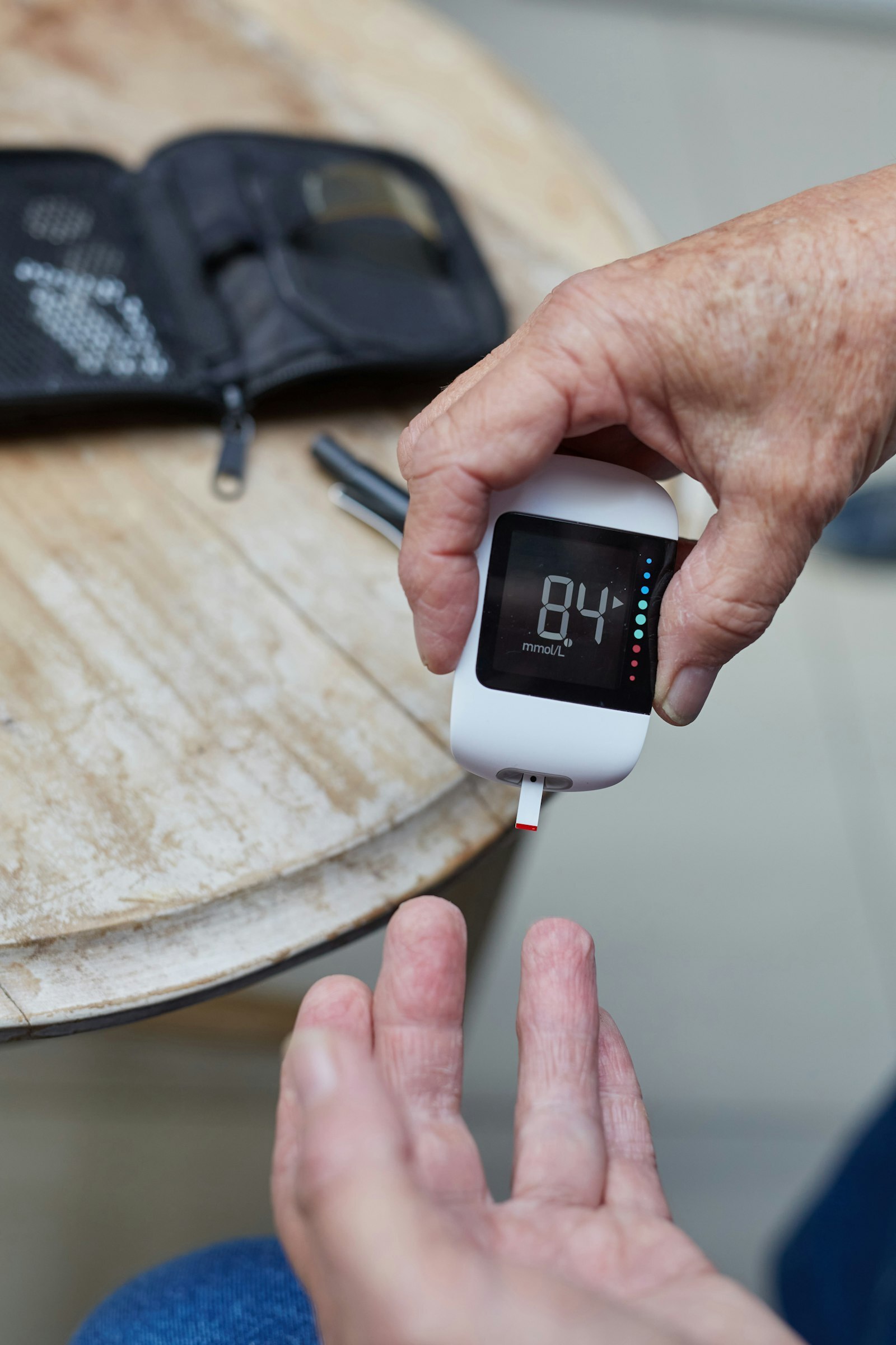 A person checking blood glucose with a connected meter